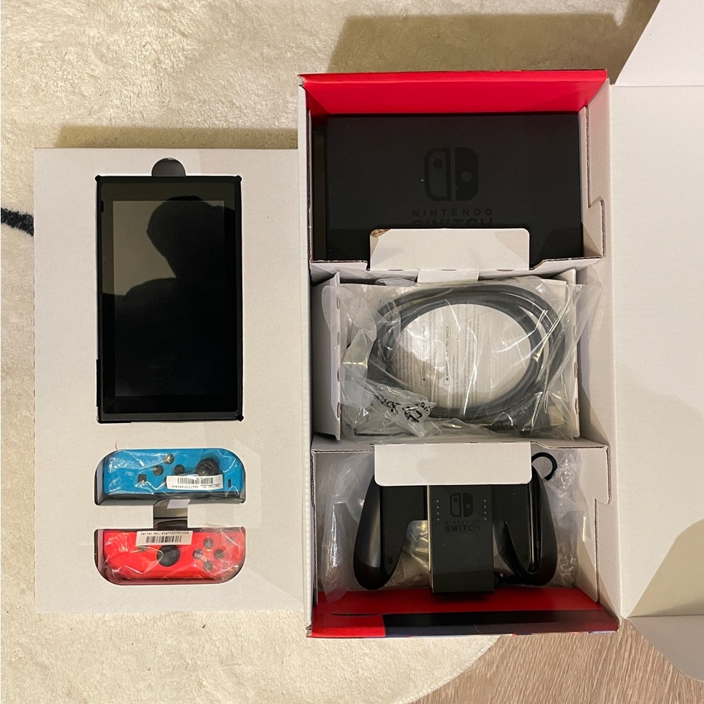 Nintendo Switch with original packaging and four games.